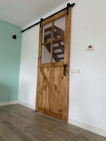 Industrieel railsysteem met oude loftdeur